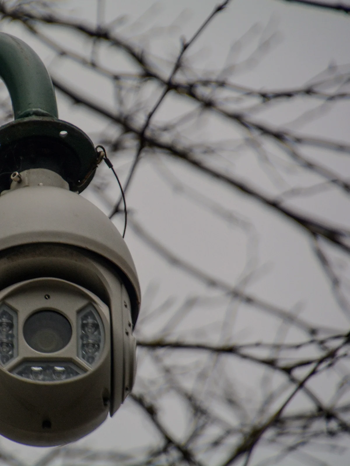 Câmera de vigilância tipo dome montada em poste, com fiação visível